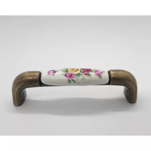 Porcelán-fém bútorfogantyú, bronz színű fém végek/tört fehér porcelán, virág mintával, 96 mm furattávval