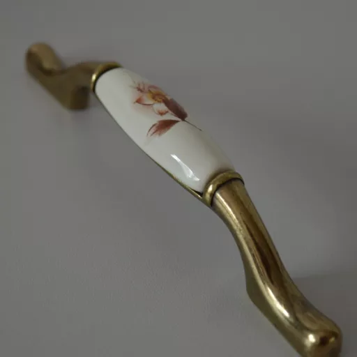 Porcelán bútorfogantyú, bronz fém végekkel - törtfehér porcelán résszel, barna virág motívummal, 96 - 128 mm furattávval
