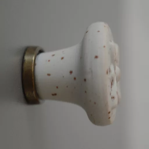 Fém-porcelán bútorgomb, fehér rozsdás hatású, bronz talprésszel, virág formájú