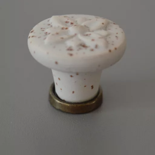 Fém-porcelán bútorgomb, fehér rozsdás hatású, bronz talprésszel, virág formájú