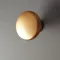 Moderner Möbelknopf aus Metall in matter Goldfarbe.