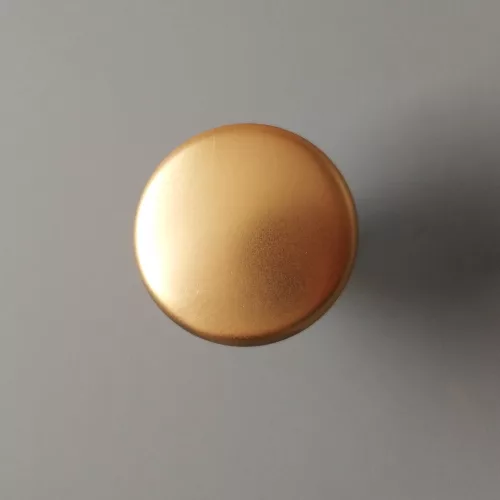 Moderner Möbelknopf aus Metall in matter Goldfarbe.