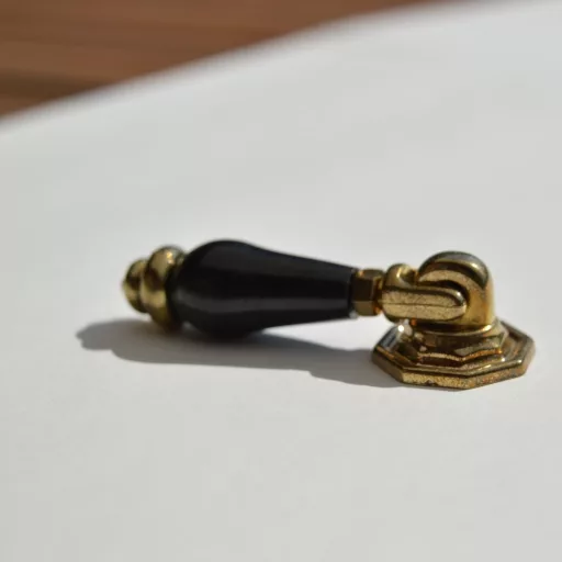 Klassischer gold-schwarzer Möbelknopf aus Metall und Kunststoff