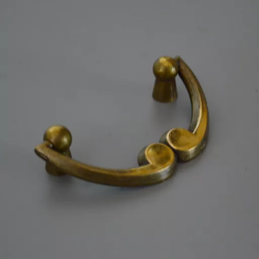 Fém bútorfogantyú,  64 mm furattáv, antik bronz szín