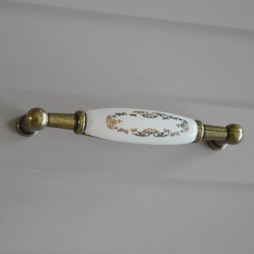 Porcelán-fém bútorfogantyú, antik bronz- arany mintával  96 mm furattávval