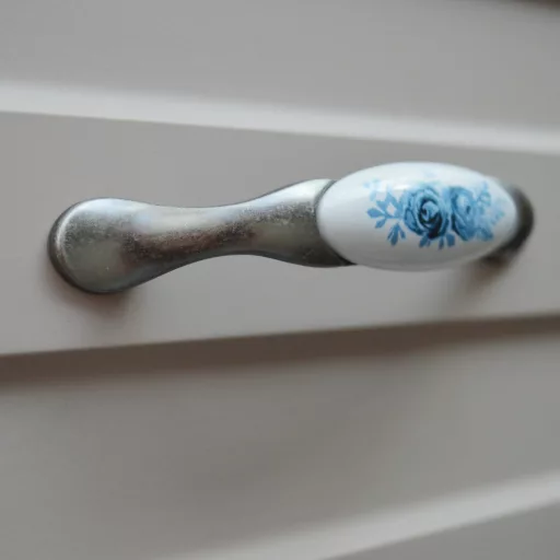 Porcelán-fém bútorfogantyú, antik ezüst - kék virág motívummal, 96 mm furattávval